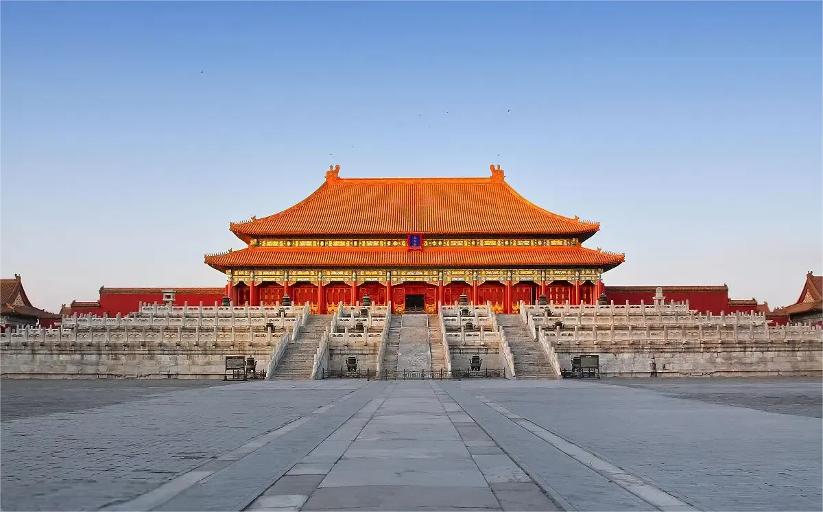 A broad courtyard facing a red palace hall with a golden roof in Beijing's Forbidden City.